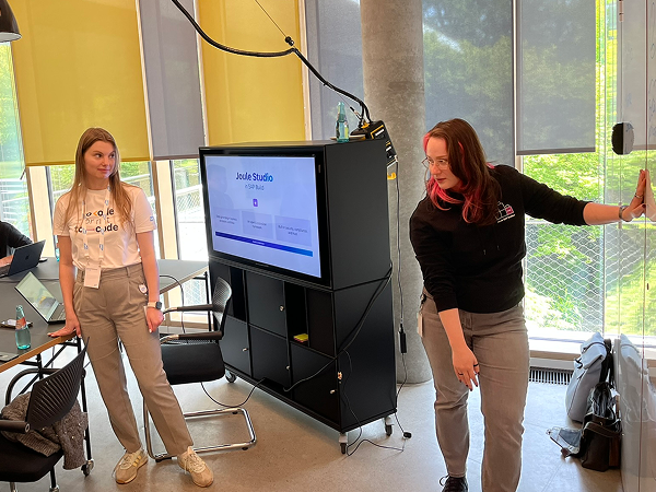 Mentoring, standing next to a screen with slides.